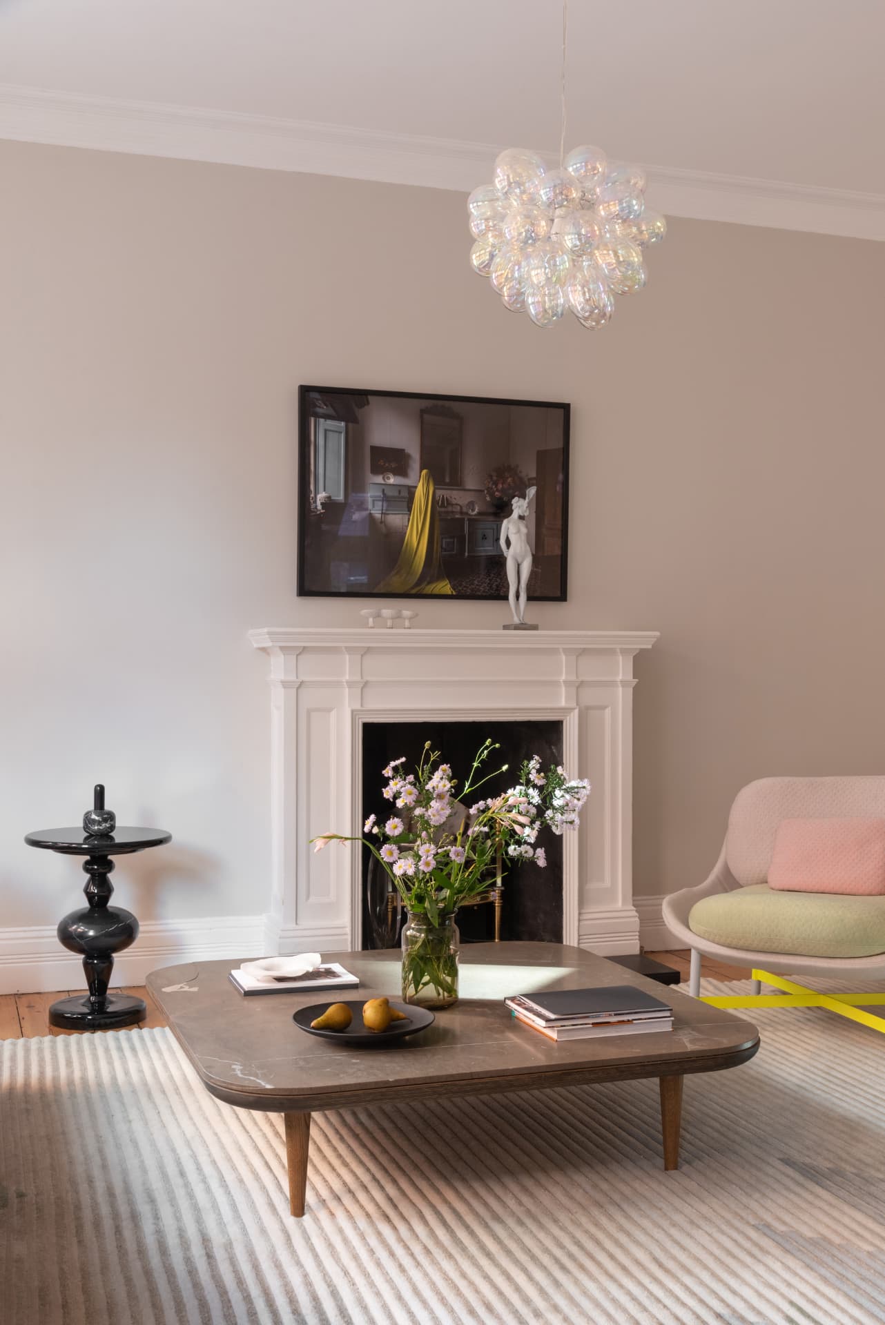 Elegant London sitting room with marble fireplace, bubble chandelier and curated art